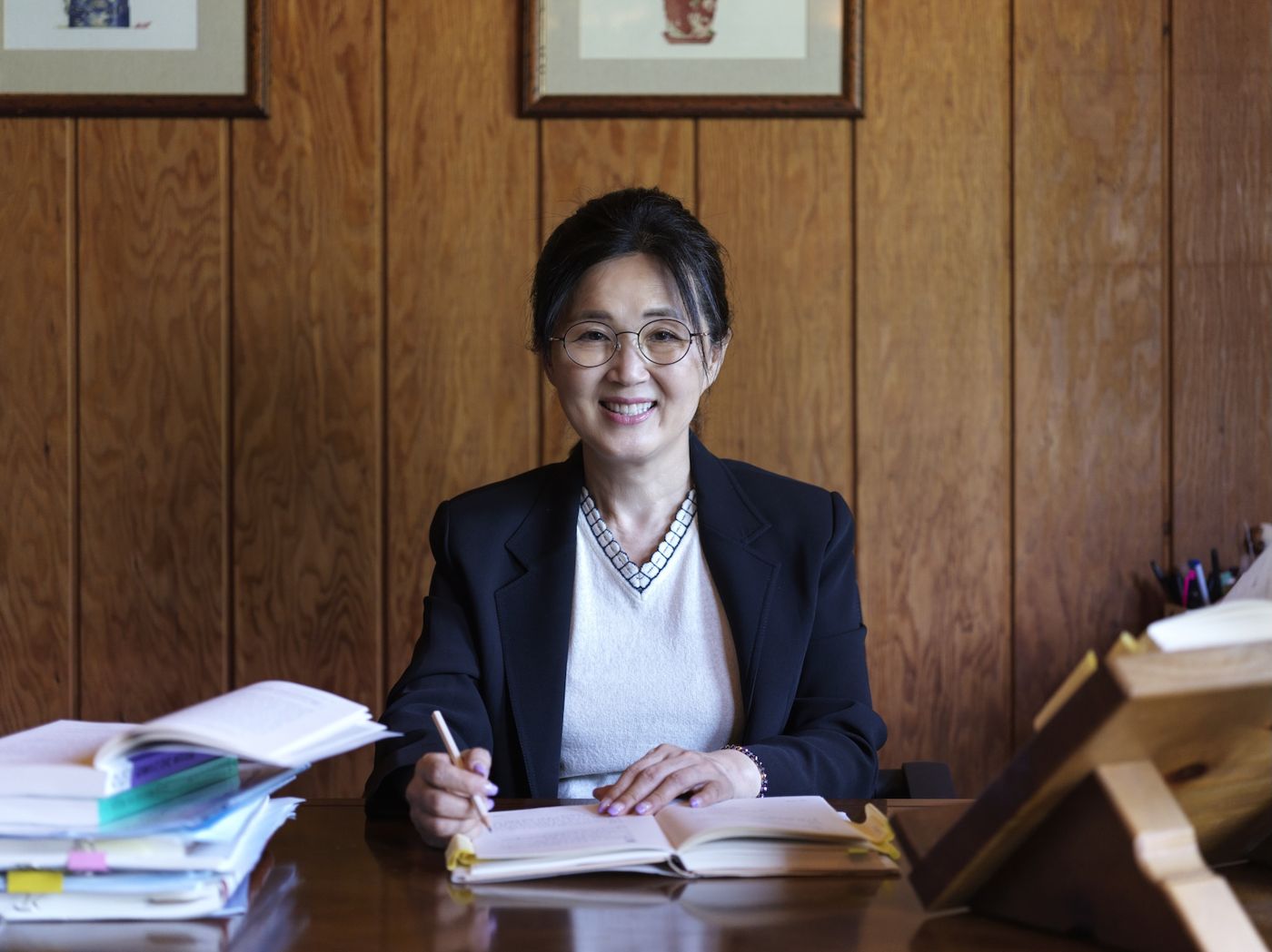 서재 책상에서 책을 펼치고 있는 정명희 박사